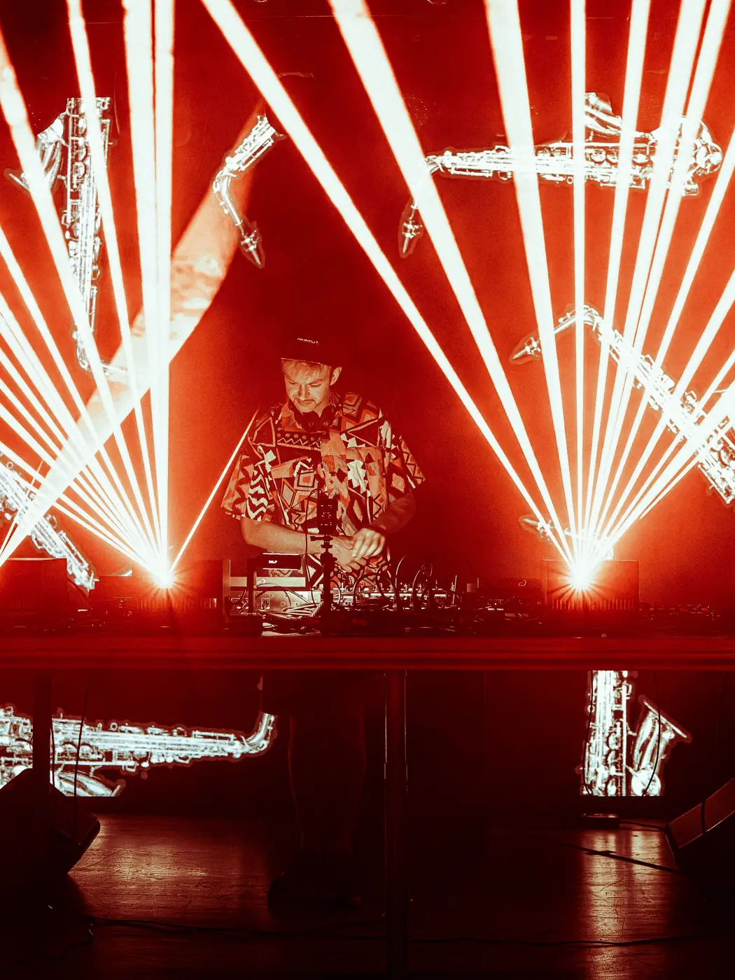 DJ framed by red and white laser fans